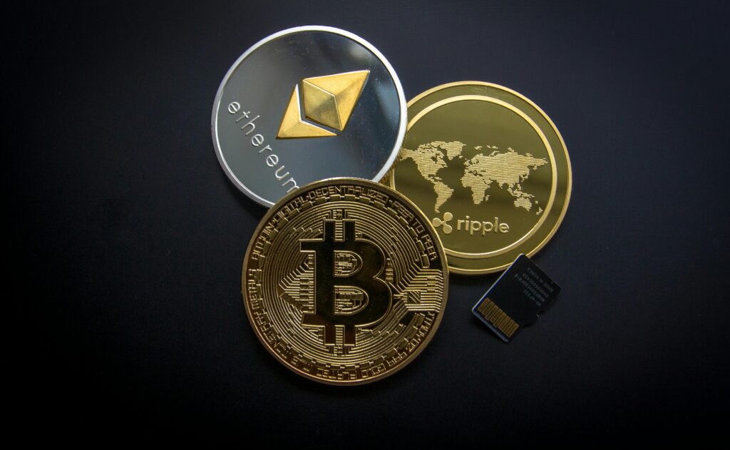 A striking image of Bitcoin, Ethereum, and Ripple coins illustrating modern digital currency. Criptomonedas.